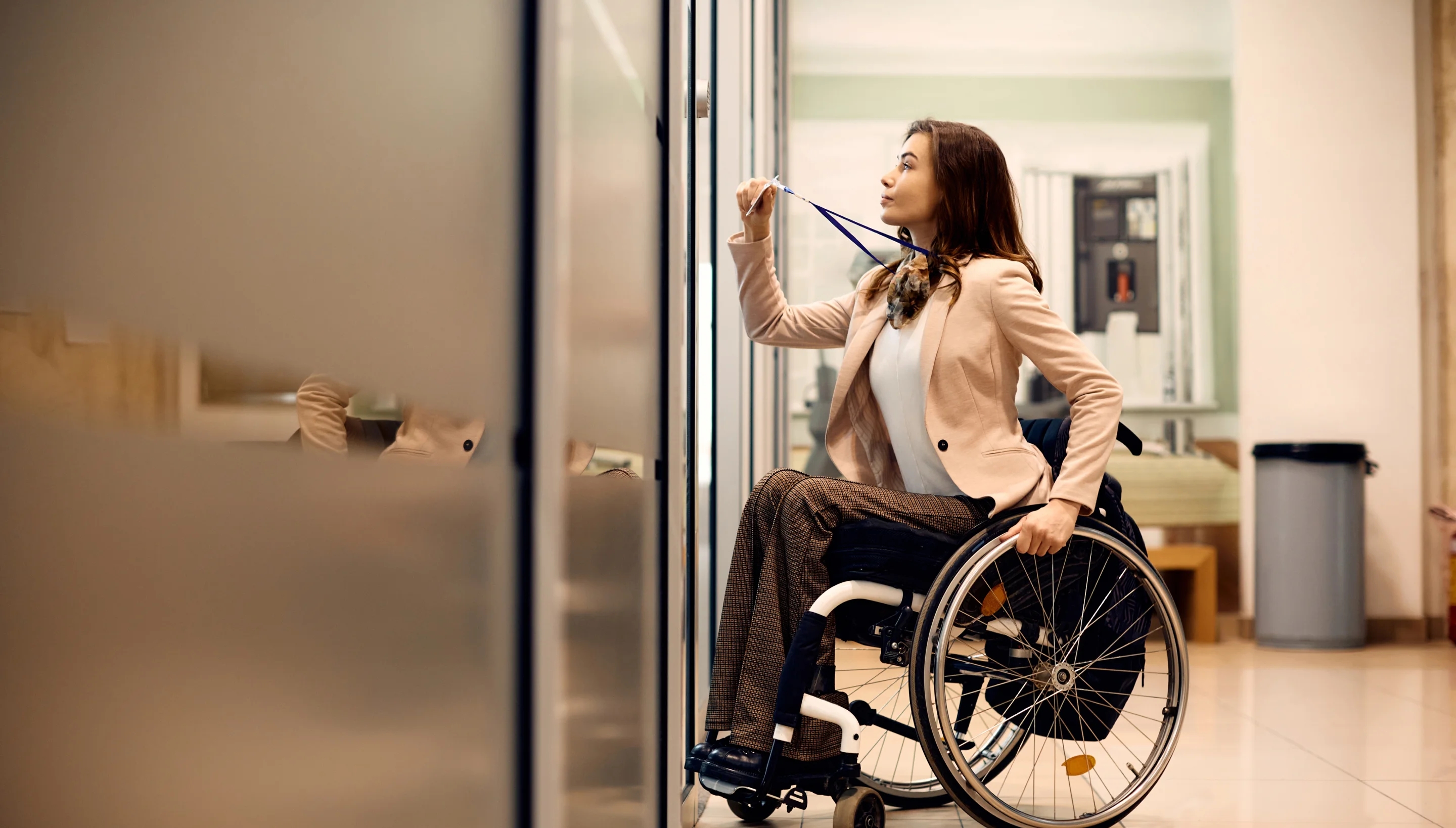 Woman in wheelchair swiping pass on lanyard